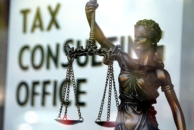 Nom : équilibre de la création de valeur / Description : statue de la justice avec la balance, devant un service des impôts